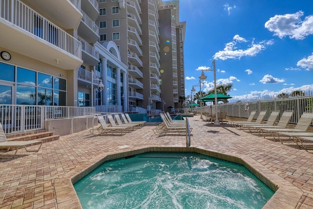 view of pool with a patio area and a hot tub