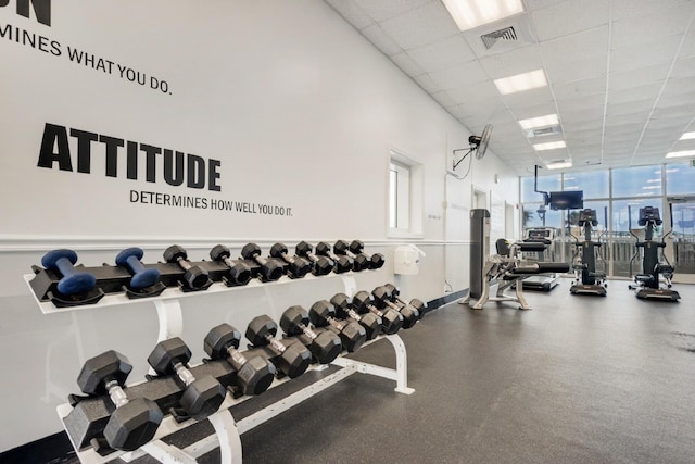 gym with floor to ceiling windows, a drop ceiling, and visible vents