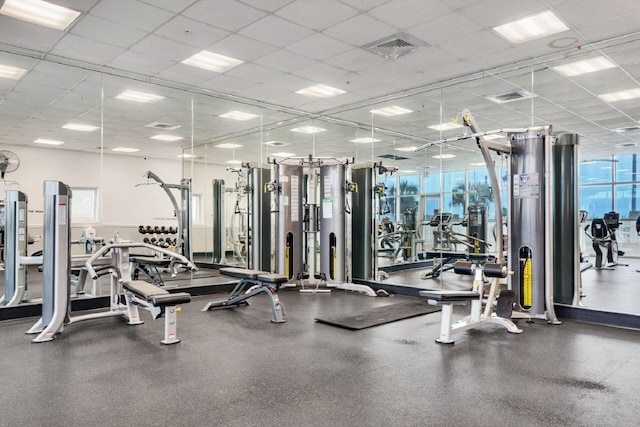 exercise room with a paneled ceiling and visible vents