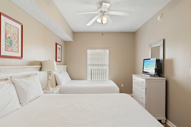 bedroom with a textured ceiling, ceiling fan, and baseboards