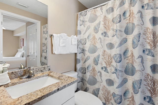 full bath with a textured ceiling, toilet, vanity, and visible vents