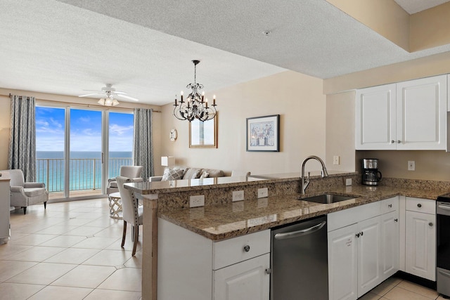 kitchen featuring light tile patterned floors, stainless steel appliances, a peninsula, a sink, and open floor plan