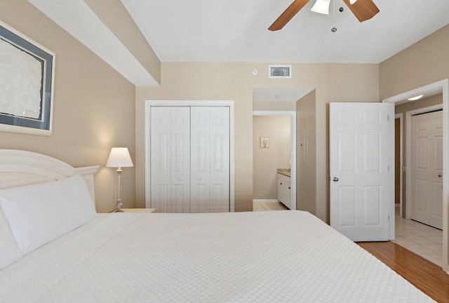 bedroom featuring a ceiling fan, a closet, visible vents, and light wood-style flooring