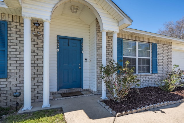 doorway to property featuring brick siding