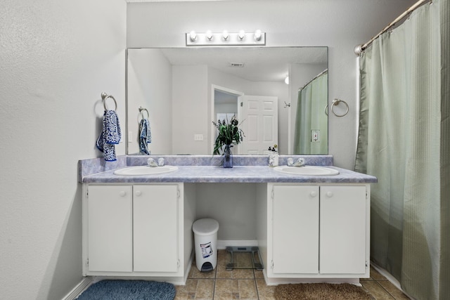 full bathroom with curtained shower, double vanity, baseboards, and a sink