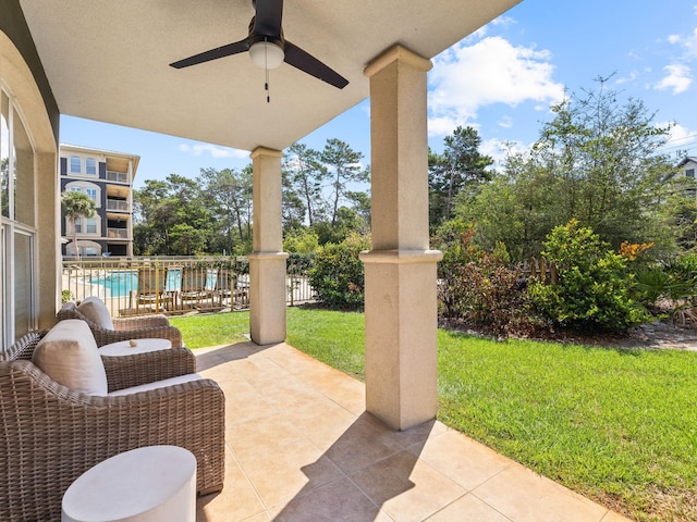 view of patio / terrace featuring a ceiling fan, fence, and a community pool