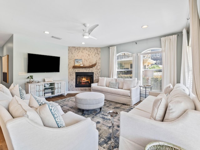 living room featuring recessed lighting, a fireplace, wood finished floors, visible vents, and a ceiling fan