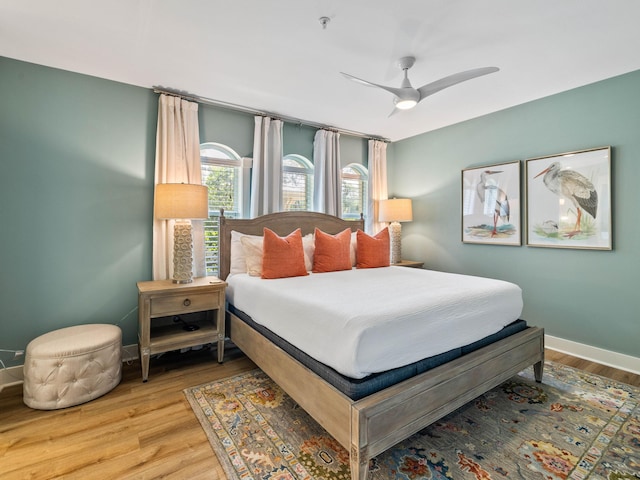 bedroom with ceiling fan, baseboards, and wood finished floors