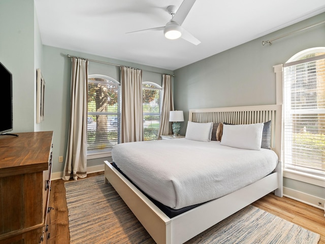 bedroom with ceiling fan, baseboards, and wood finished floors