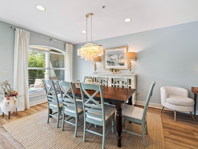 dining room featuring light wood-style floors, baseboards, a notable chandelier, and recessed lighting