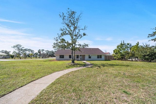 ranch-style home with fence and a front lawn