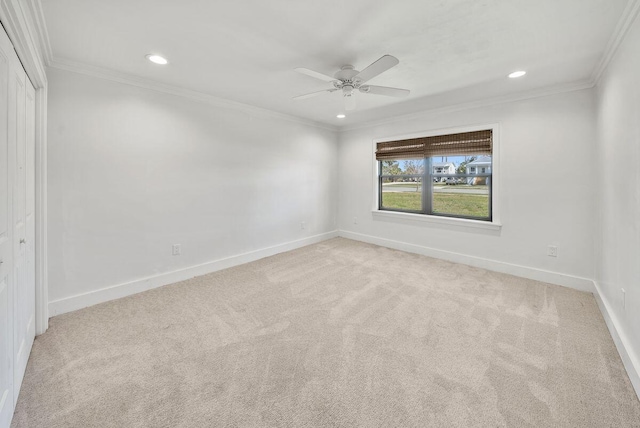 spare room featuring ornamental molding, light colored carpet, and baseboards