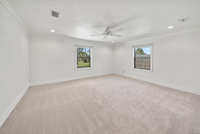 empty room with baseboards, visible vents, and crown molding