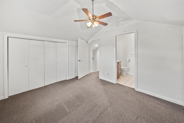 unfurnished bedroom with carpet, lofted ceiling, a closet, a ceiling fan, and ensuite bath