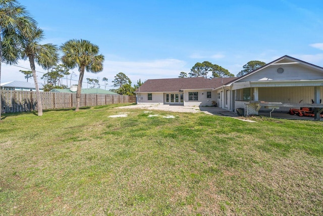 rear view of property with a patio area, a lawn, and fence