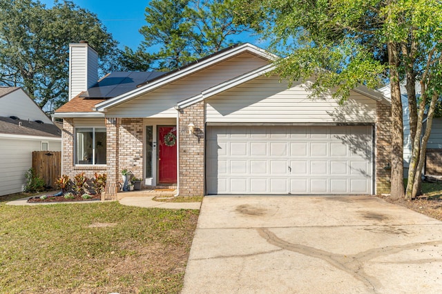 ranch-style home with a garage, driveway, solar panels, a chimney, and a front lawn