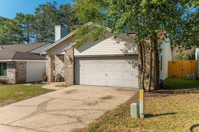 view of front of property with brick siding, a chimney, an attached garage, driveway, and a front lawn