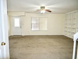 unfurnished room with carpet floors and a ceiling fan