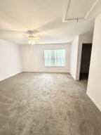 carpeted empty room featuring attic access