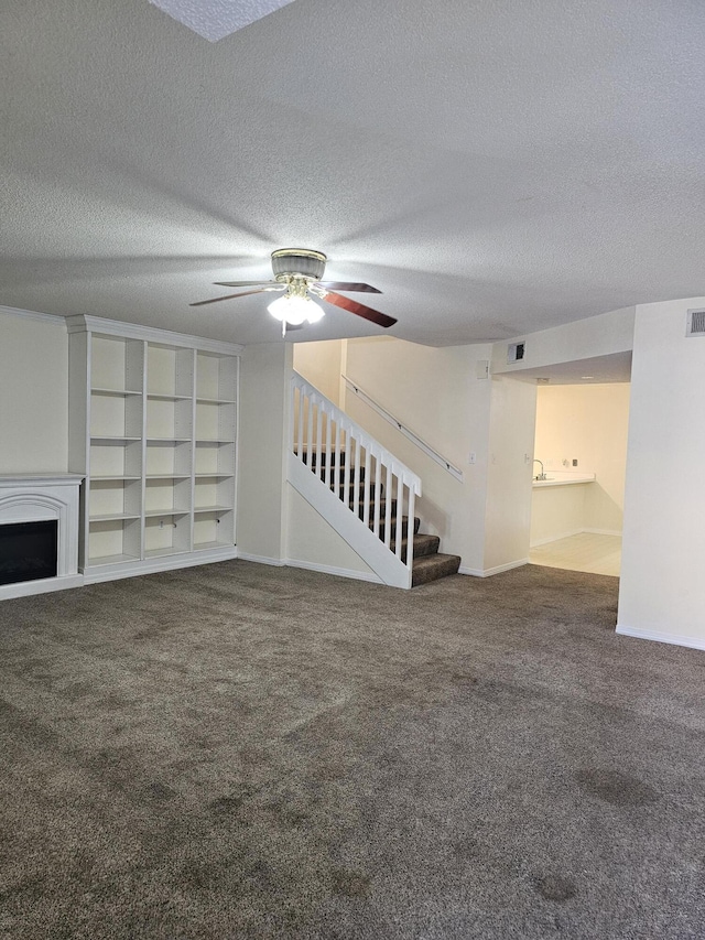 946 Ashley Ln Unit C, Fort Walton Beach, FL 32547 - unfurnished living room featuring stairway, carpet, a fireplace, a ceiling fan, and a textured ceiling
