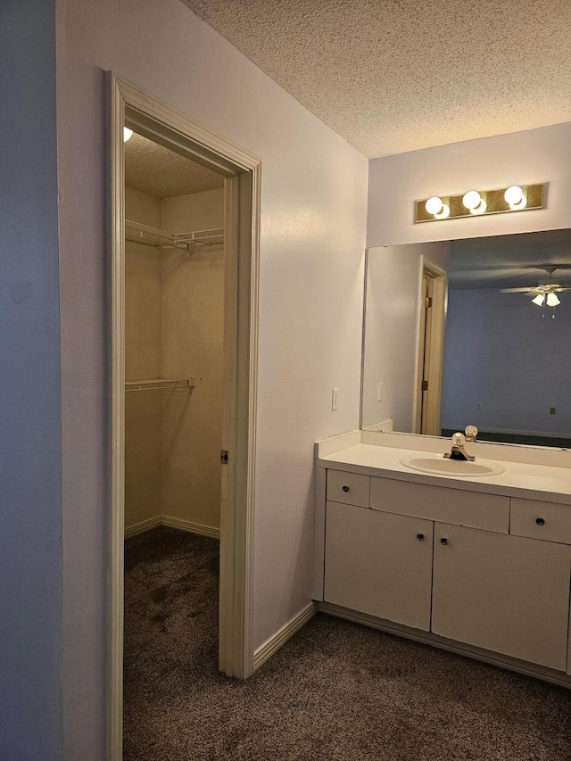 946 Ashley Ln Unit C, Fort Walton Beach, FL 32547 - bathroom with vanity, a textured ceiling, a ceiling fan, a spacious closet, and baseboards