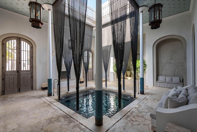 interior space with arched walkways, french doors, and a towering ceiling