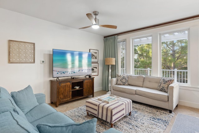 living room with light tile patterned flooring, ceiling fan, and baseboards