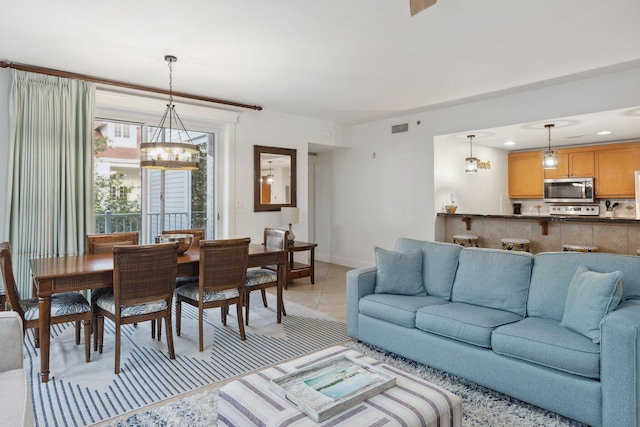 living room with visible vents, a notable chandelier, recessed lighting, light tile patterned flooring, and baseboards