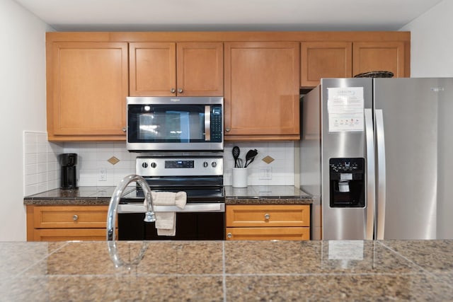 kitchen featuring tile counters, brown cabinetry, tasteful backsplash, and appliances with stainless steel finishes