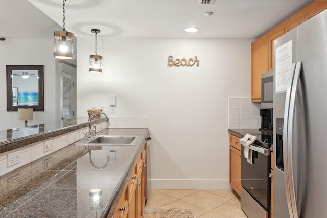 kitchen with tile countertops, light tile patterned floors, a sink, decorative backsplash, and stainless steel appliances