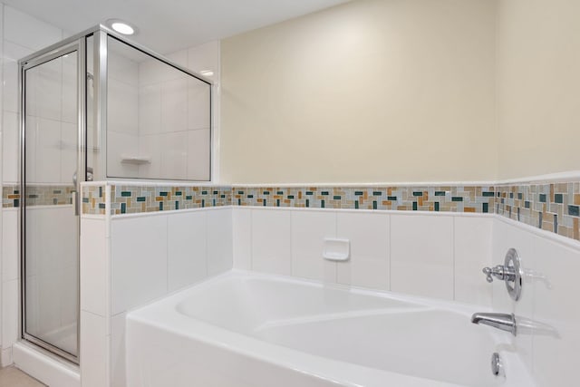 bathroom with recessed lighting, a shower stall, and a garden tub