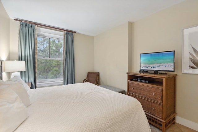 bedroom with light tile patterned floors and baseboards