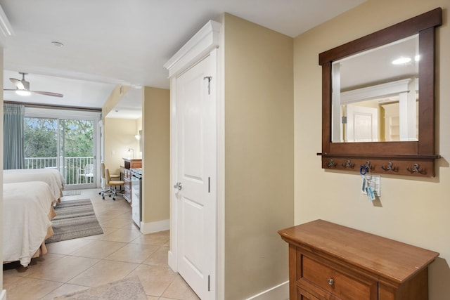 corridor featuring light tile patterned floors and baseboards