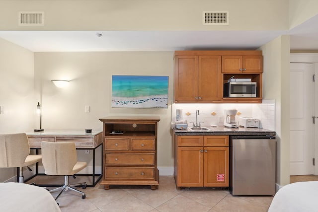 kitchen featuring fridge, stainless steel microwave, visible vents, and a sink