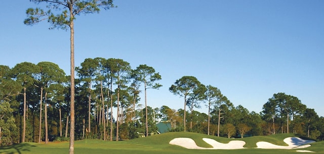 view of home's community featuring a yard and view of golf course