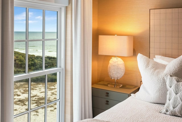 bedroom with multiple windows and a water view