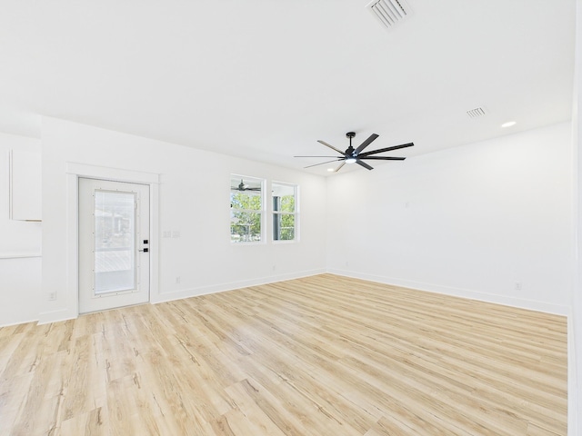 empty room featuring baseboards, light wood-type flooring, visible vents, and a ceiling fan