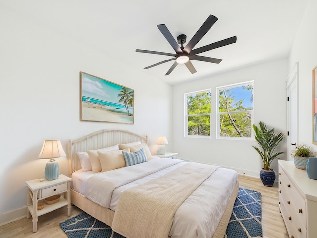 bedroom featuring light wood-style floors, ceiling fan, and baseboards