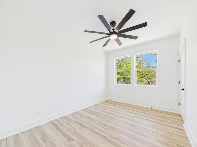 spare room featuring light wood-style flooring, baseboards, and ceiling fan