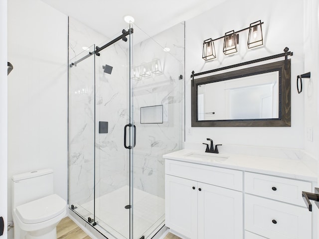 full bath with a marble finish shower, vanity, and toilet