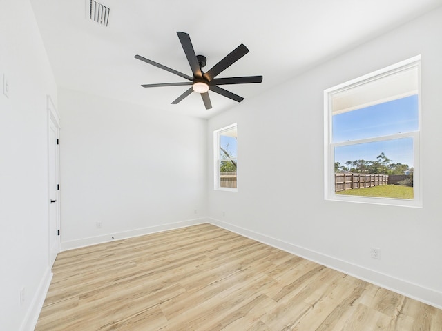 spare room with light wood-style floors, baseboards, visible vents, and ceiling fan