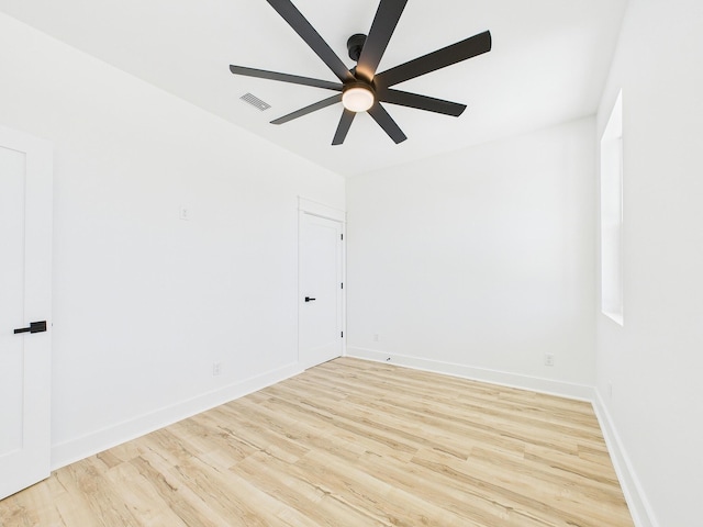 empty room featuring baseboards, visible vents, ceiling fan, and wood finished floors