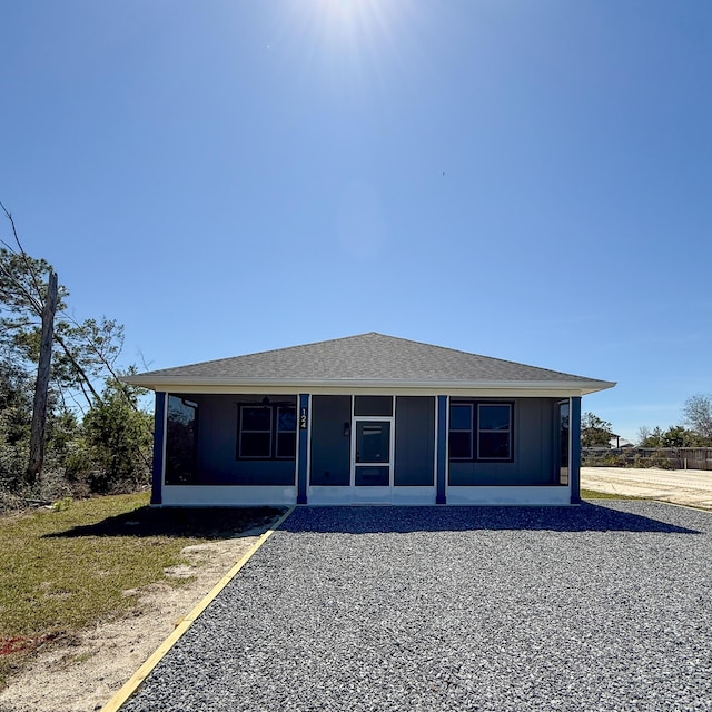 back of property featuring a shingled roof and a sunroom