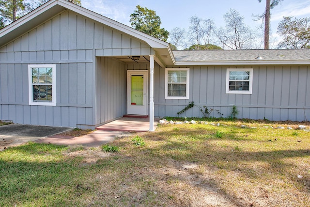 view of front facade with a front yard and roof with shingles