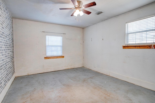 unfurnished room with a ceiling fan, visible vents, brick wall, and unfinished concrete floors