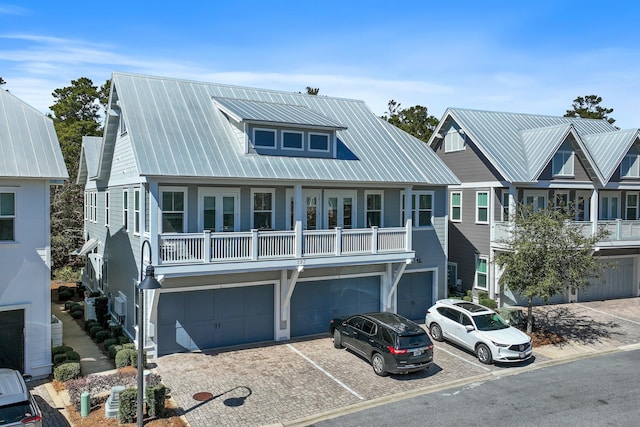 view of front of home featuring an attached garage, driveway, and metal roof