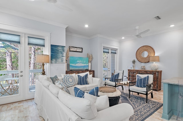 living room with ornamental molding, light wood-type flooring, french doors, and visible vents