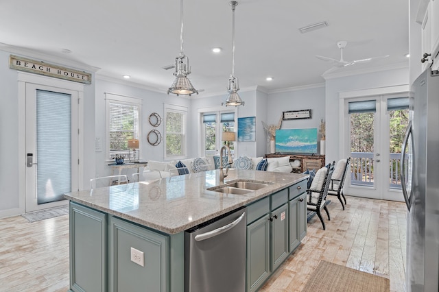 kitchen featuring french doors, crown molding, appliances with stainless steel finishes, a sink, and light wood-type flooring