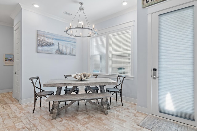 dining room with baseboards, an inviting chandelier, light wood-style flooring, and crown molding