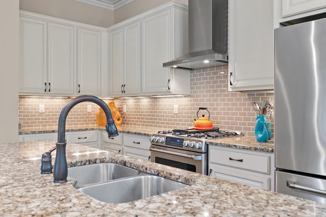 kitchen featuring white cabinetry, wall chimney exhaust hood, appliances with stainless steel finishes, and backsplash